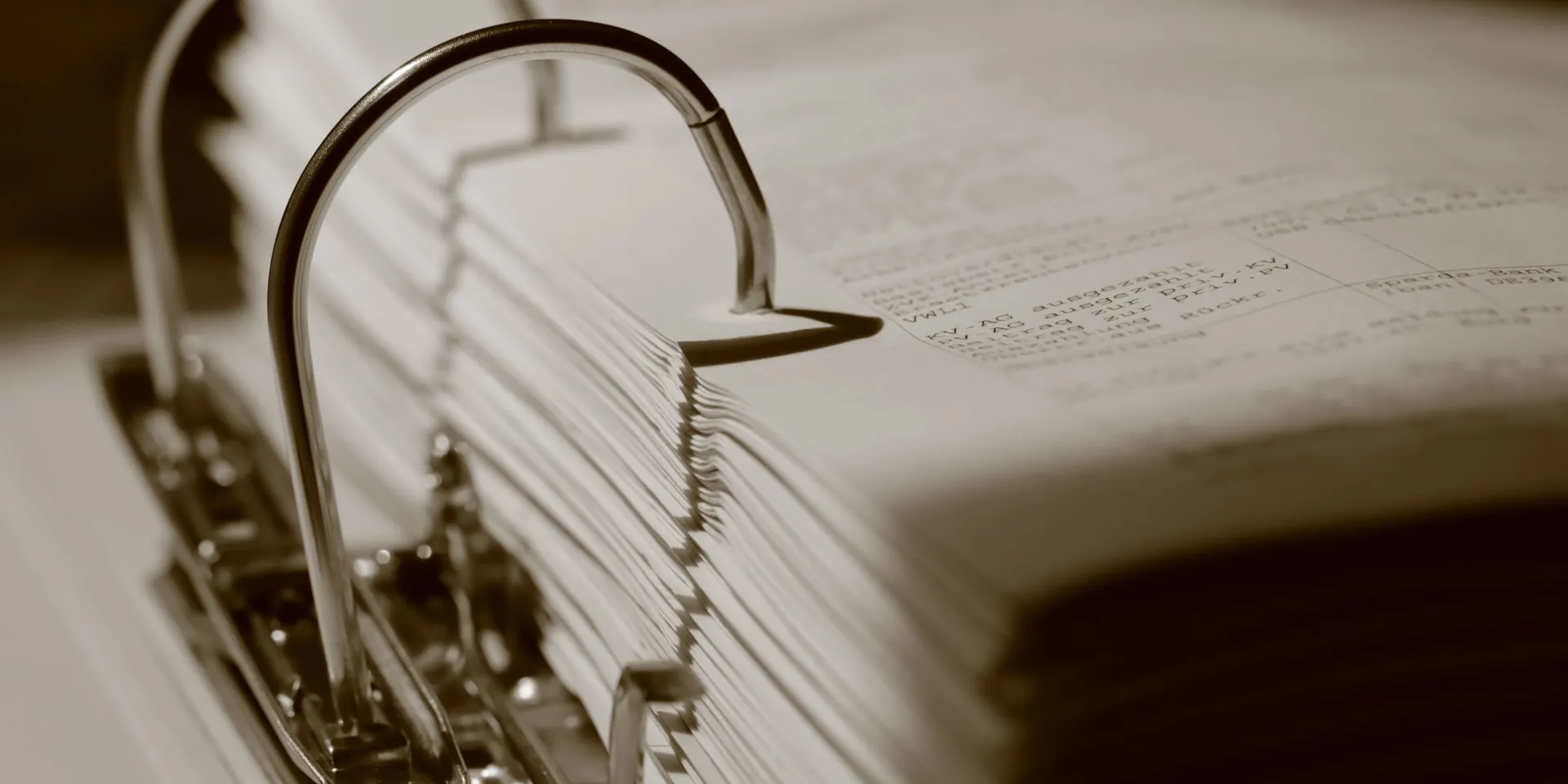 Classeur à anneaux rempli de documents, en tons sépia