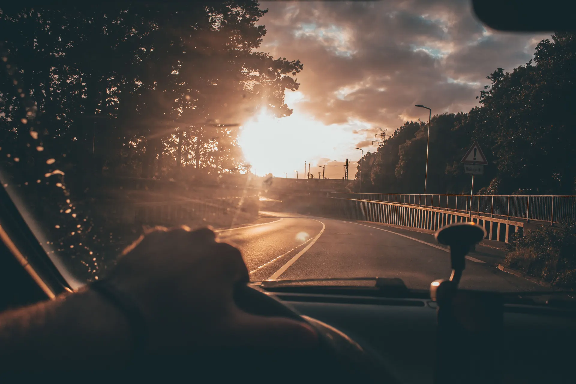 Conducteur au volant sur une route face au soleil couchant, assurance pour conducteur résilié