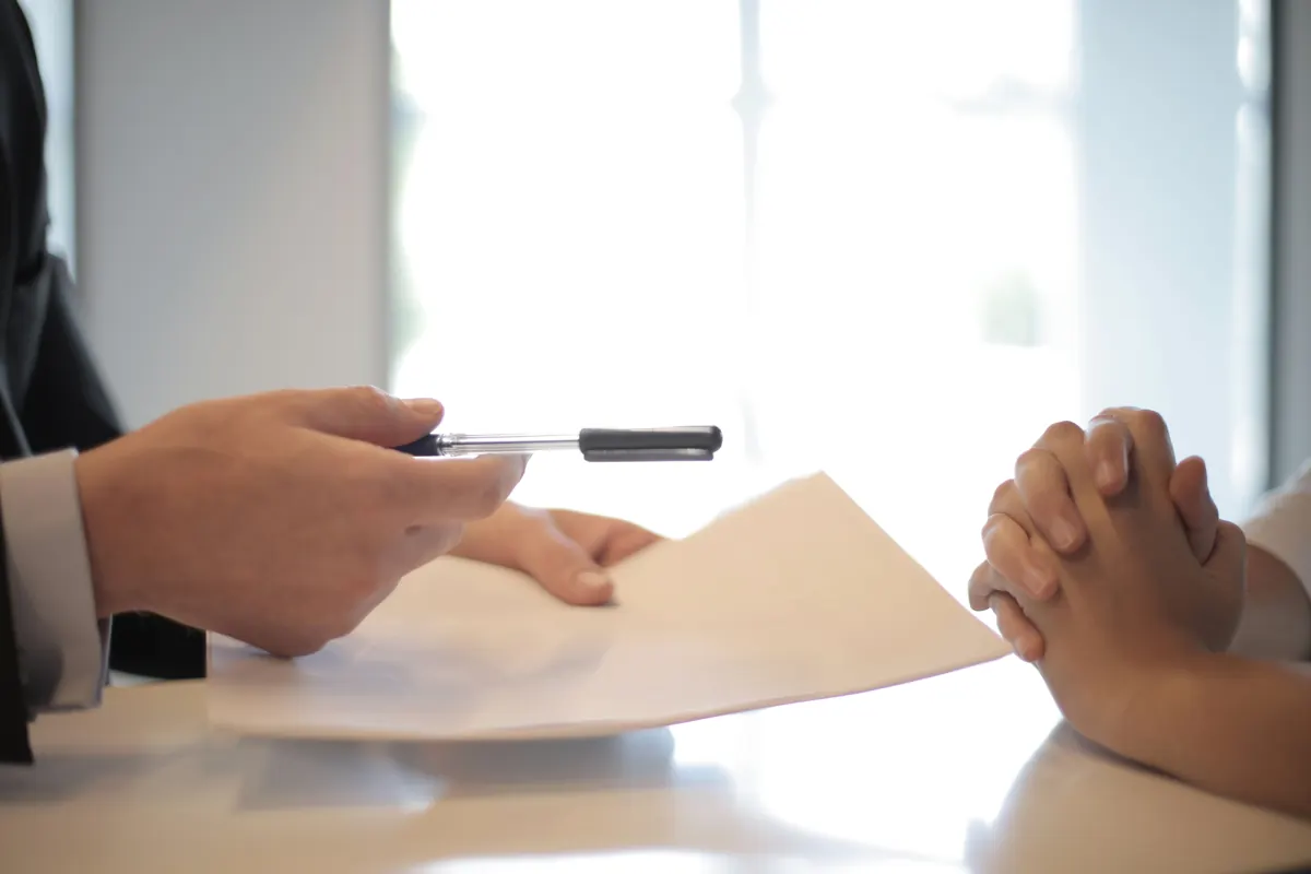 Conseiller tendant un contrat et un stylo à un client, solution d'assurance après résiliation
