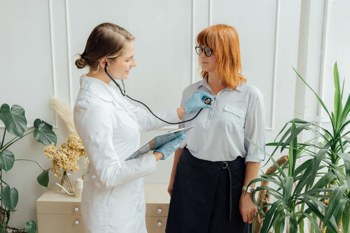 Médecin prenant la tension d'une patiente lors d'une consultation