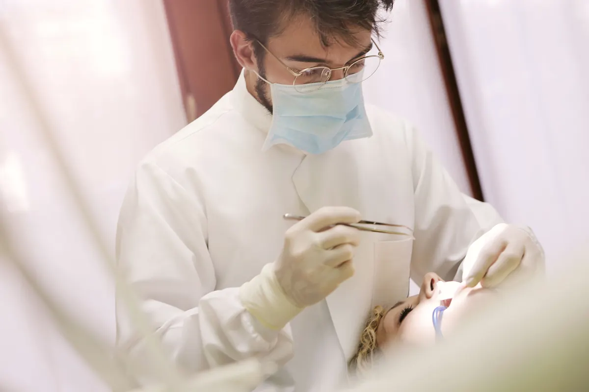 Dentiste soignant un patient au cabinet, prise en charge des soins dentaires