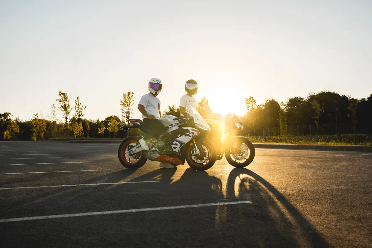 Deux motards casqués sur leurs motos sportives à contre-jour en fin de journée