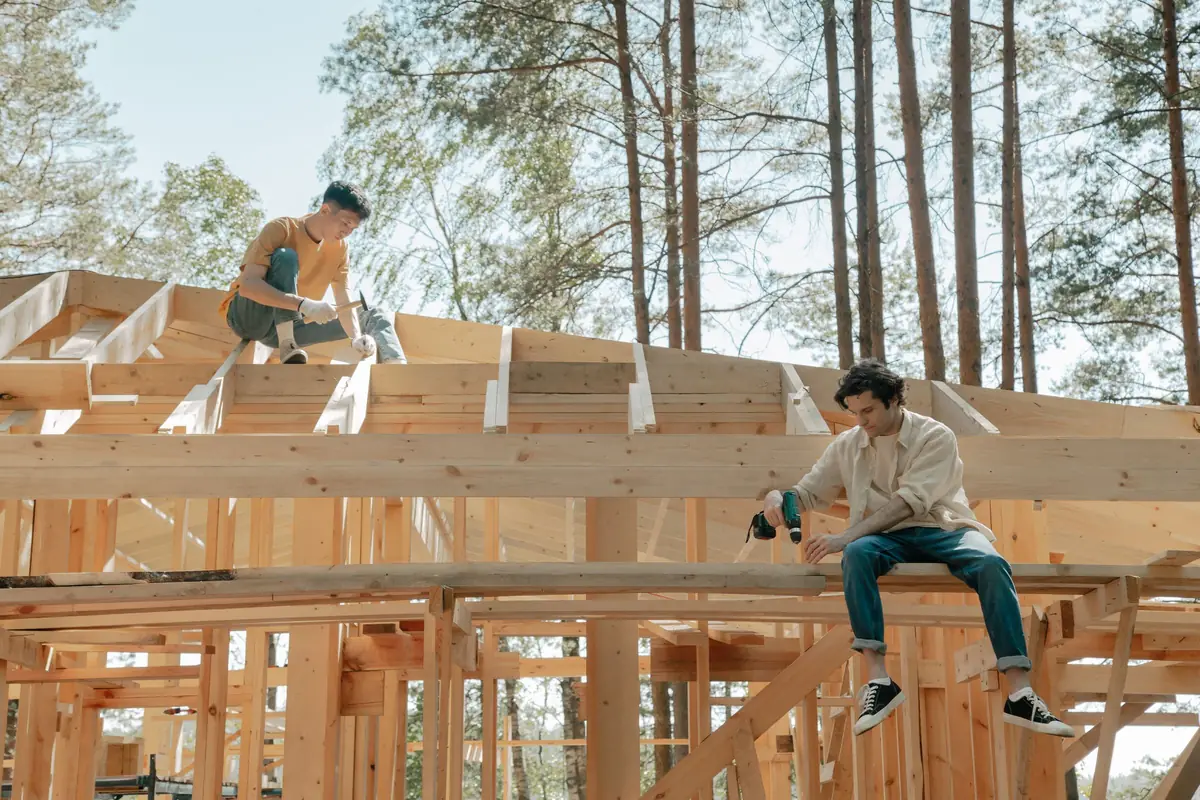 Deux charpentiers travaillant sur la structure en bois d'une maison