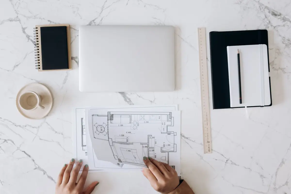 Bureau d'architecte avec plans, ordinateur portable et documents d'un projet de construction