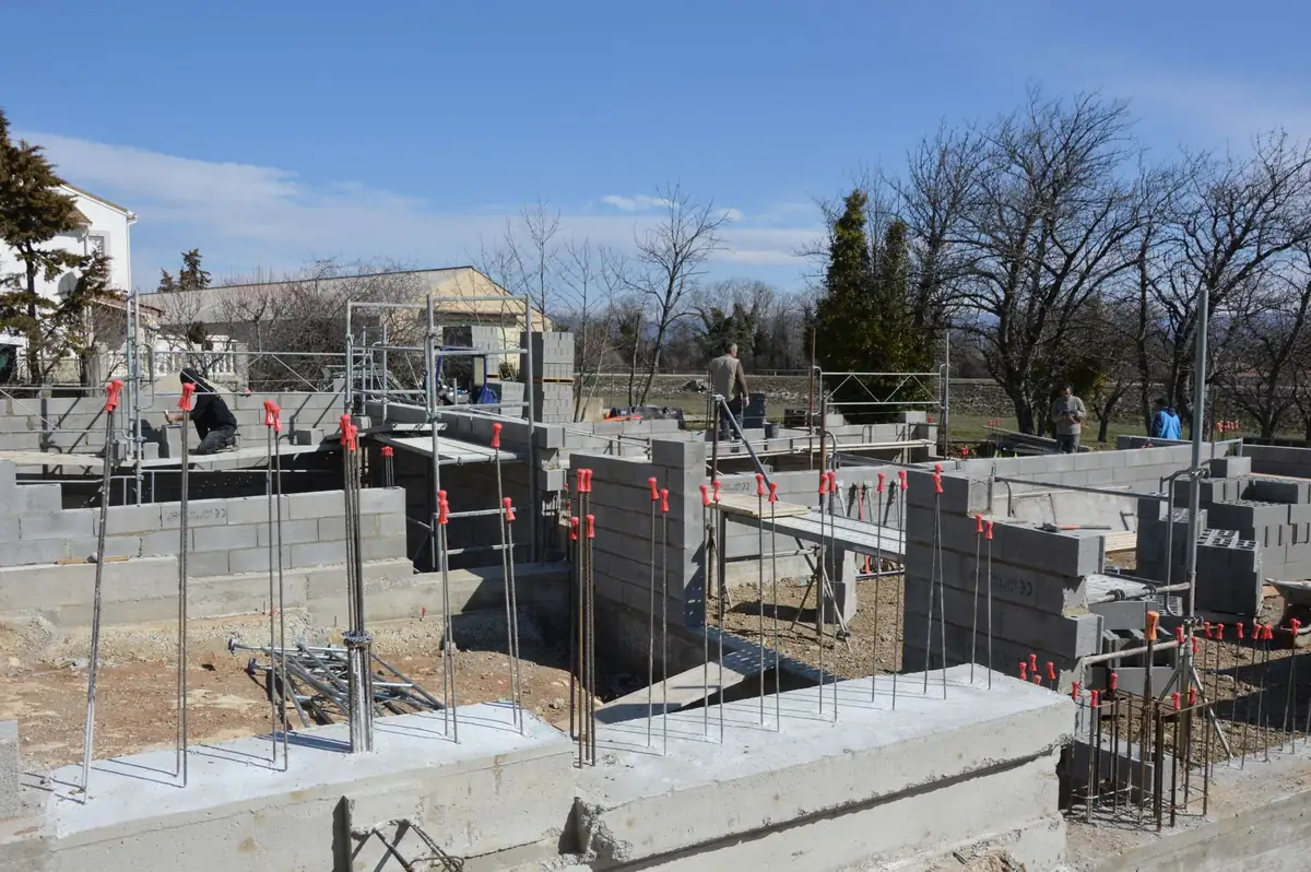 Fondations en béton et armatures d'un chantier de maison avant la construction des murs