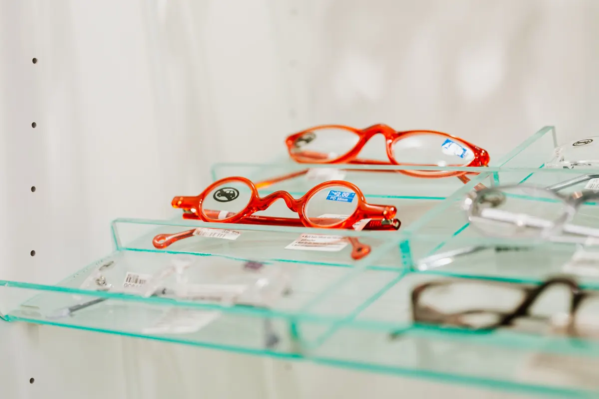 Montures de lunettes rouges sur le présentoir d'un opticien, garanties optique