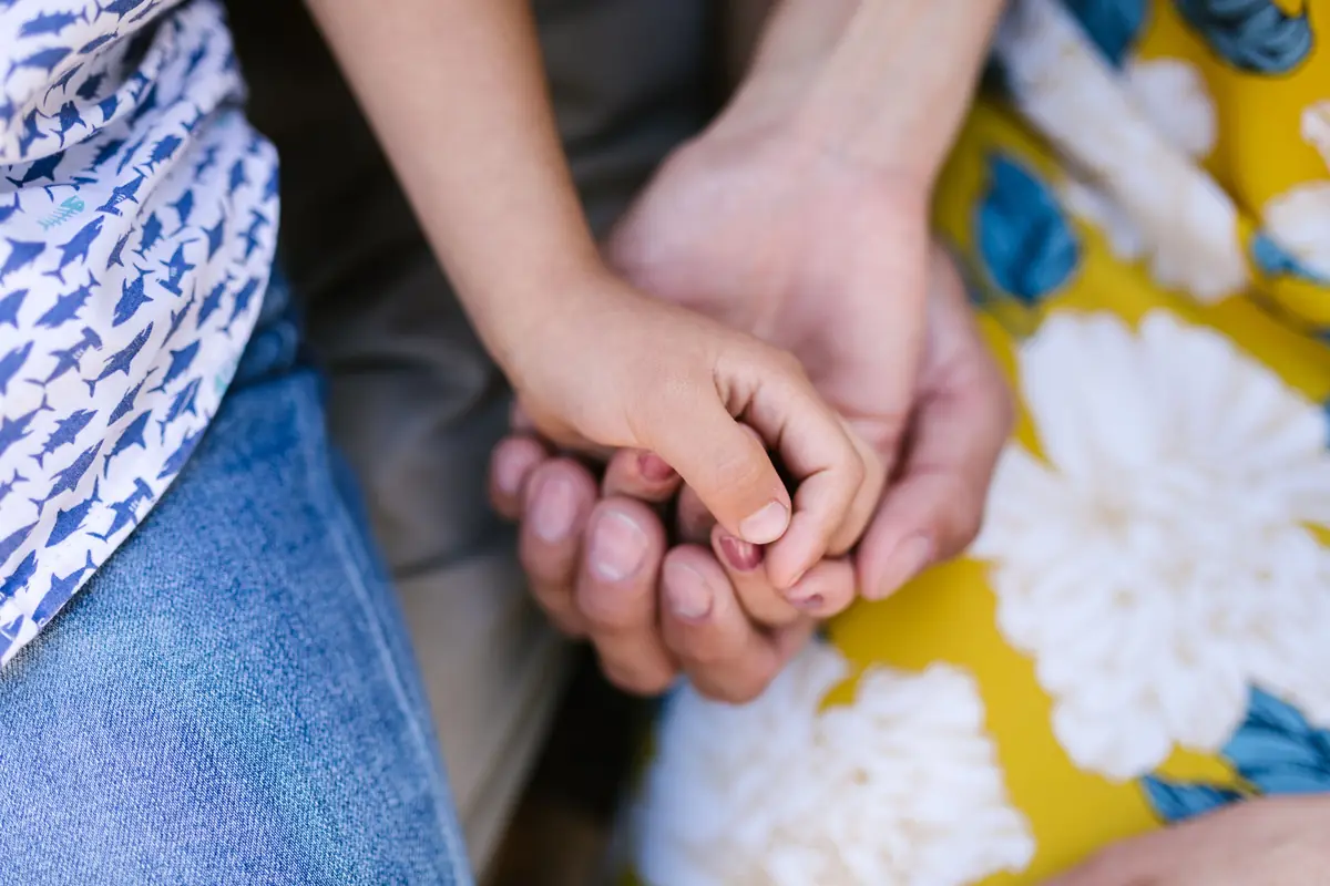 Main d'enfant tenue par celle d'un parent, mutuelle santé pour toute la famille