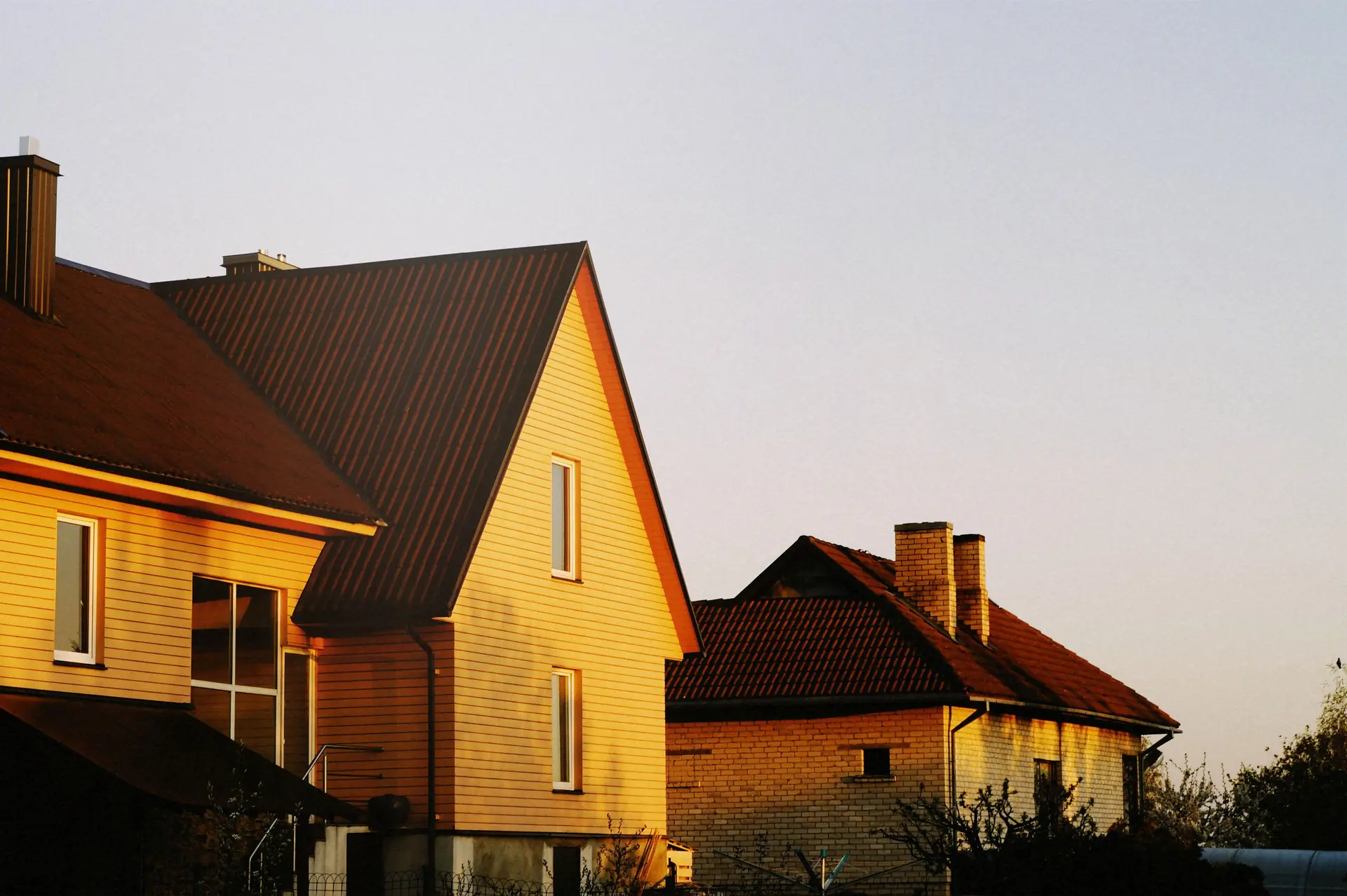 Façades de maisons éclairées par la lumière dorée du soir, assurance habitation propriétaire ou locataire