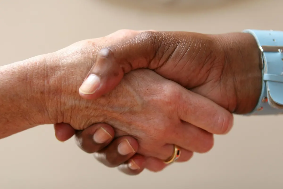 Poignée de main chaleureuse scellant un accord entre un artisan et son assureur