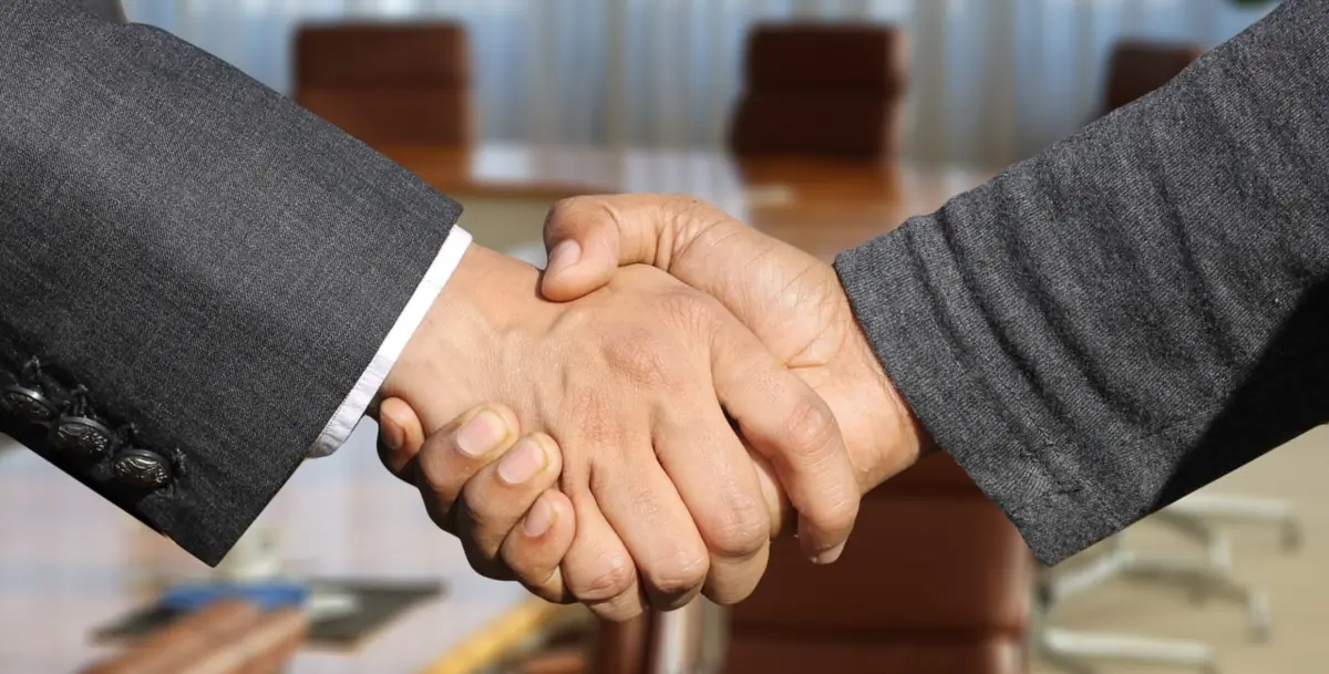 Poignée de main d'accueil entre un conseiller et un client dans un bureau