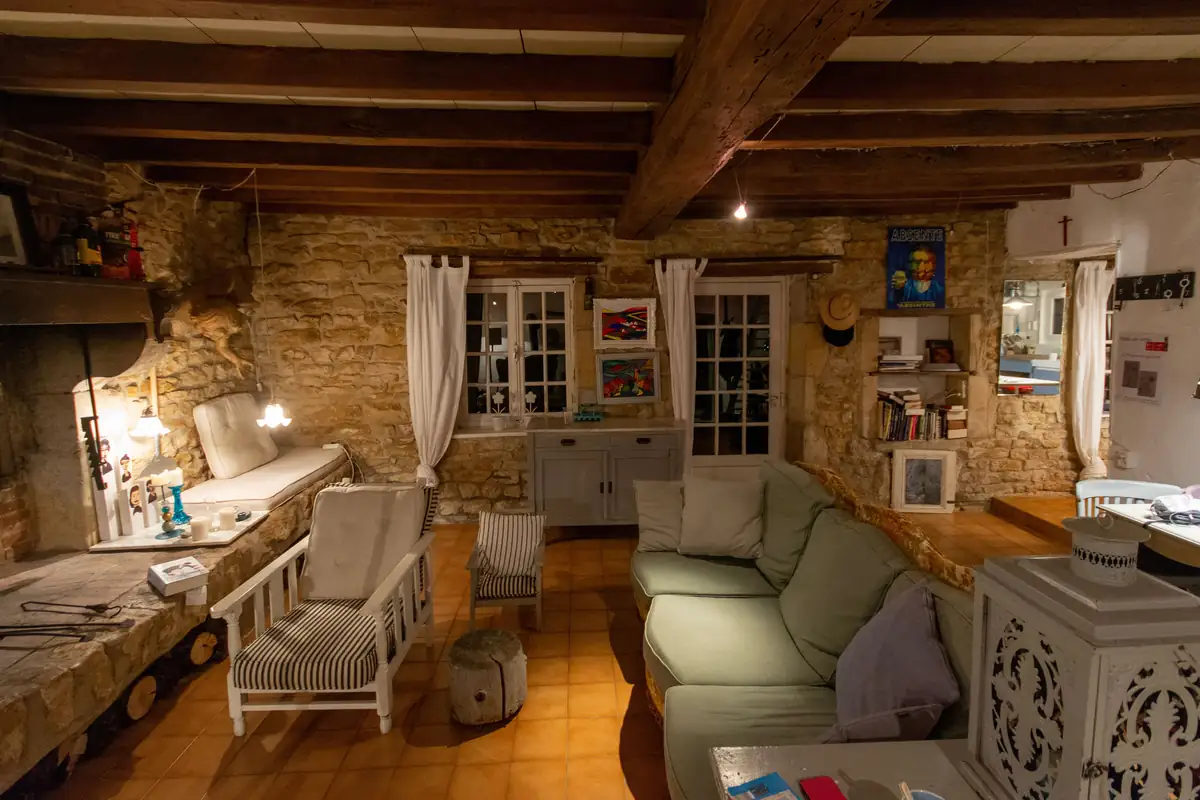 Salon chaleureux aux murs en pierre et poutres apparentes, mobilier et biens à assurer