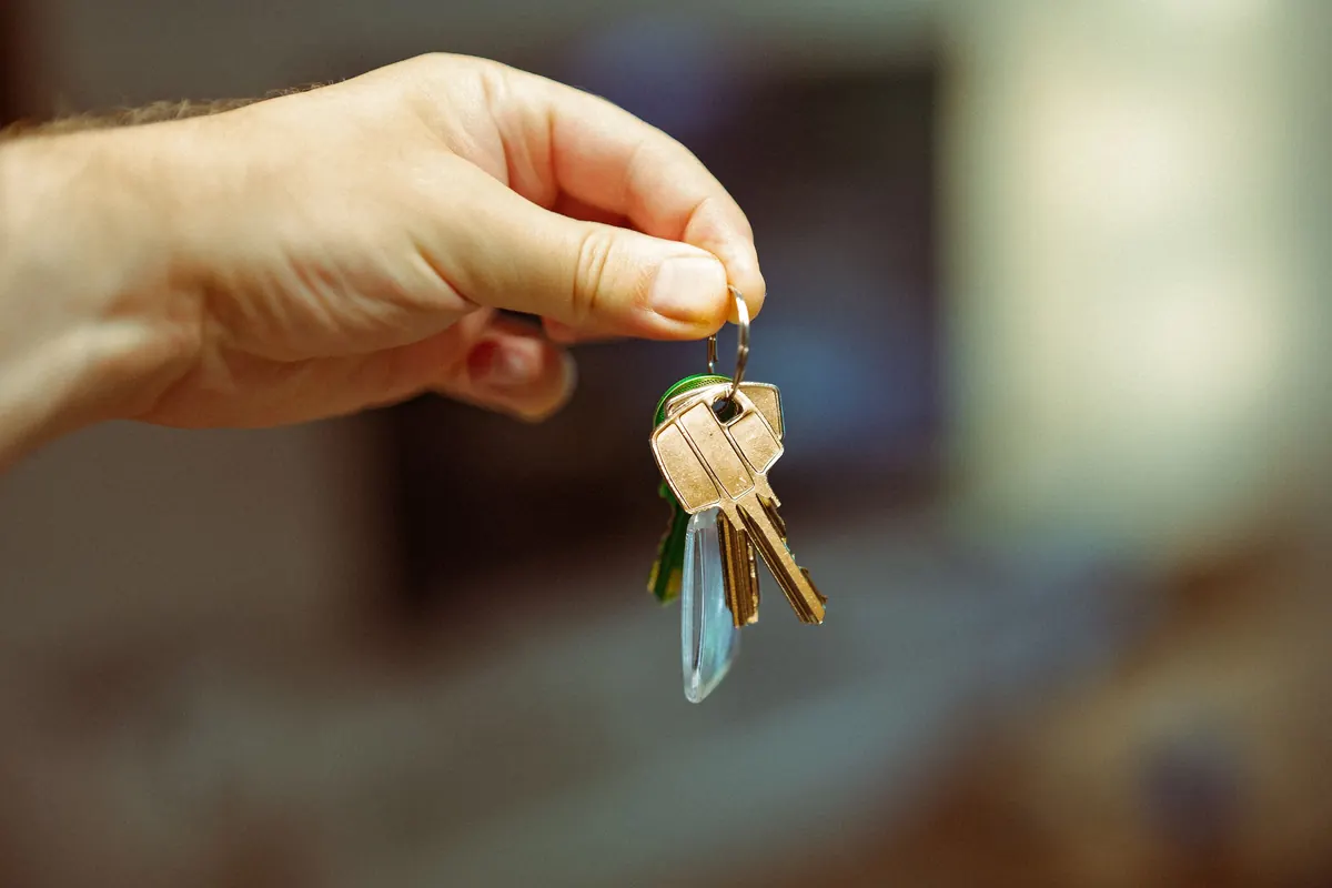 Main tenant un trousseau de clés de maison, emménagement et assurance du logement